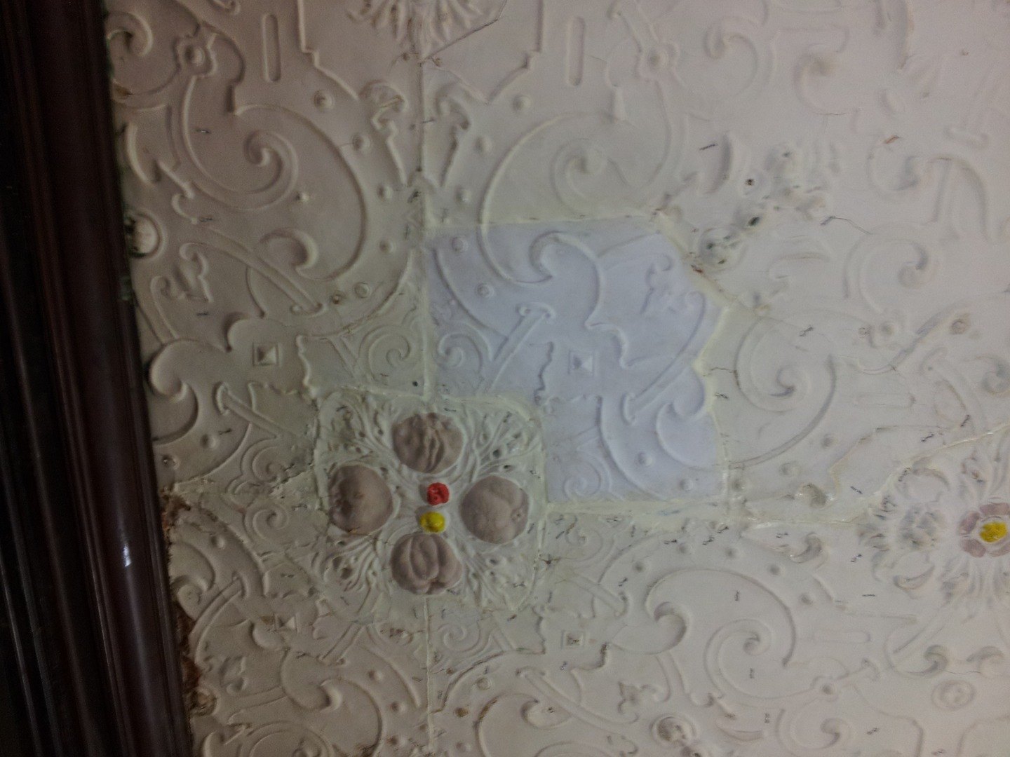 A patterned Victorian papier mache ceiling with a patch of new work let in