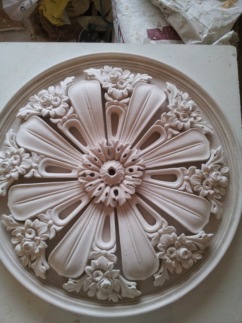 A round ceiling centre with broad petals and small flowers round the rim