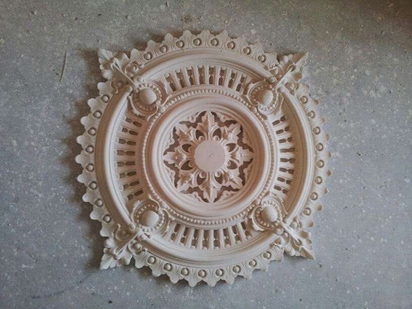 An ornate pierced ceiling rose with a beaded rim