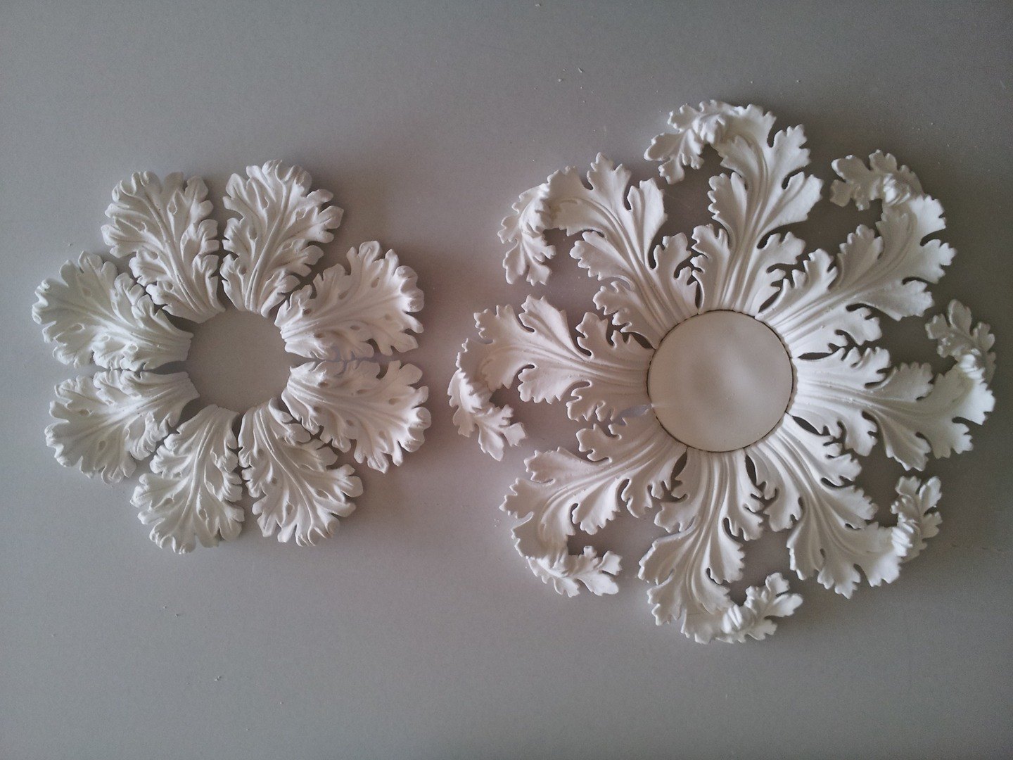 Two spiral acanthus ceiling roses side by side on the bench